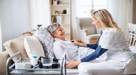 Home caregiver assisting patient recovery in India